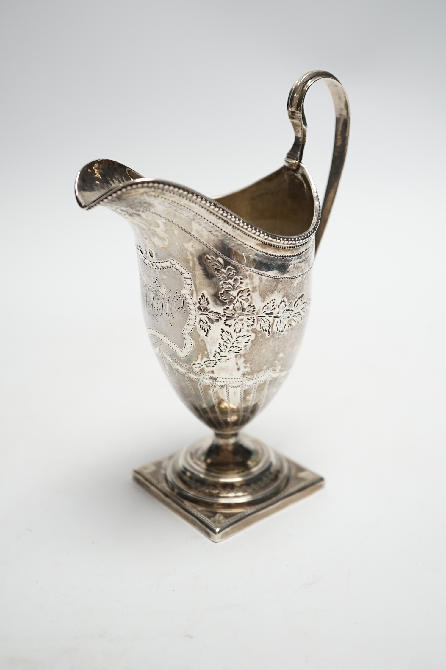 A George III engraved silver helmet shaped cream jug, on square foot, Soloman Hougham, London, 1796, 15cm, 3.6oz.